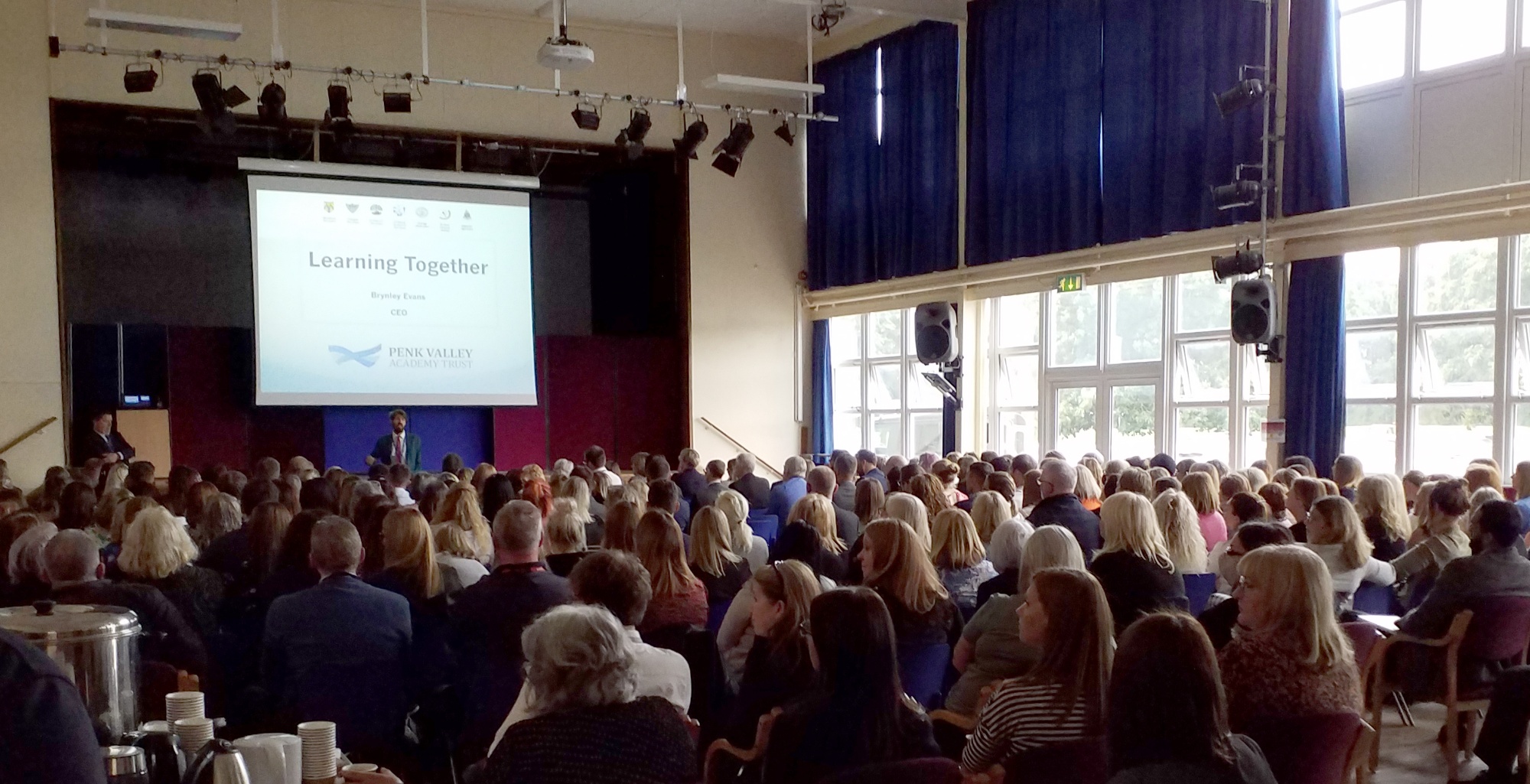 A large audience attending a curriculum development presentation at Penk Valley Academy Trust, focused on subject mastery and teaching strategies.